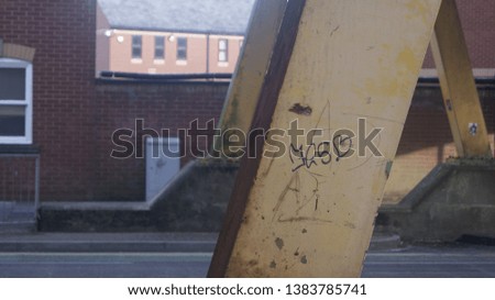 Lover's graffiti written on a bridge pillar, placed on the right third. Slight bokeh on the background.