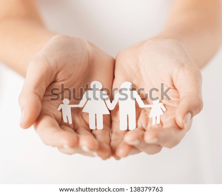 close up of womans cupped hands showing paper man family Royalty-Free Stock Photo #138379763