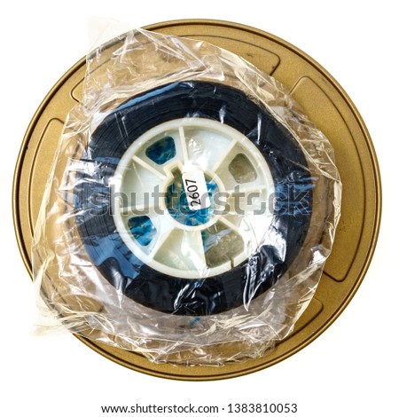 real 35mm plstic spool or reel in foil on movie tin isolated on white background