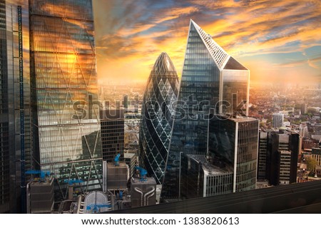 City of London, UK. Skyline view of the famous financial bank district of London at golden sunset hour. View includes skyscrapers, office buildings and beautiful sky. 