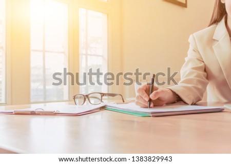 Female businessmen are checking the property accounts and annual sales to summarize the results.
Businessmen are summarizing sales to close the annual budget alone near the window in the morning.