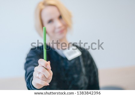 Female hand holding a green marker.