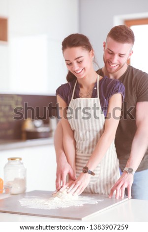 Young couple prepared cake standing in the kitchen