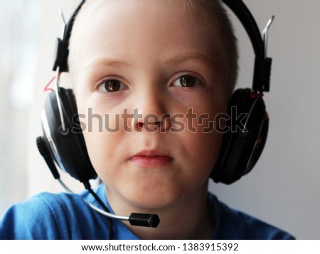 Blond boy in big headphones, a portrait