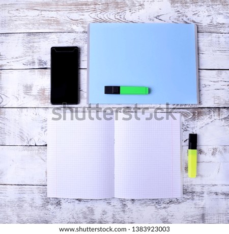 Notebooks, smartphone and markers on white table. Office flat lay
