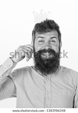 Birthday party of cheerful bearded man, celebration concept. Happy man with long beard and big smile holding paper crown from party set. Bearded hipster in pink shirt posing with paper accessories.