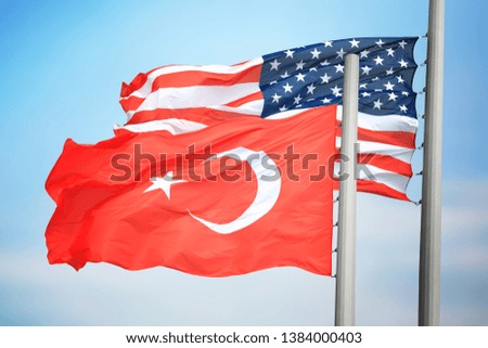 Flags of Turkey and the USA against the background of the blue sky