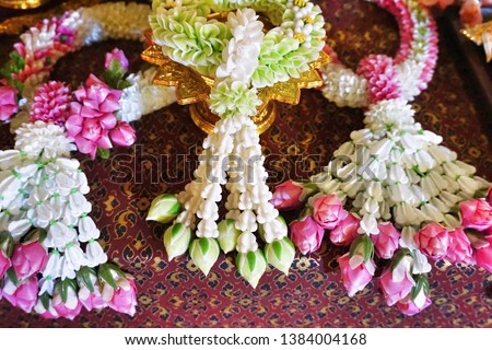 Thai garlands are created by stringing various flower combinations together. The mixture usually includes one or more fragrant flowers like jasmine, crown flowers and rose buds. Selective focus.