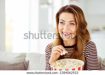 Close up photo beautiful she her model lady hands big container corns arms comic serial fast unhealthy food wear jeans denim striped pullover clothes sit comfort cosy divan house living room indoors