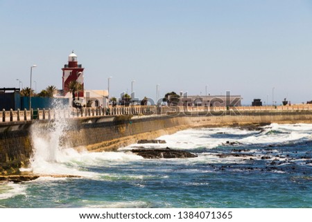 Strong waves bounce against wave protection, breakwater, Sea Point promenade in Cape Town, South Africa. Royalty-Free Stock Photo #1384071365