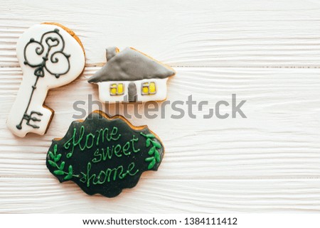 Key, house, welcome sign cookies on white wood, flat lay with space for text. Dream home concept. Home Sweet Home. Moving in new house, Welcome home set.