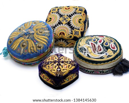 The traditional Uzbek hat, called a skullcap,or Duppi, is decorated with colorful embroidery on the white background    Royalty-Free Stock Photo #1384145630
