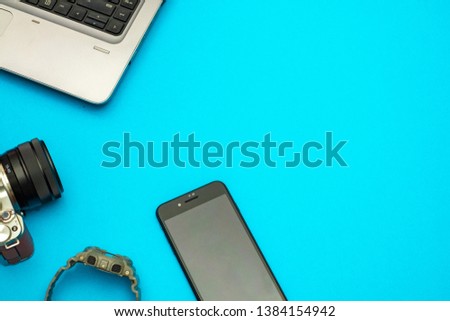 blue office photography desk table with laptop, tablet ,watch and camera . Top view with copy space