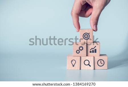 Woman hand arranging wood block with icon business strategy and Action plan, copy space. Royalty-Free Stock Photo #1384169270