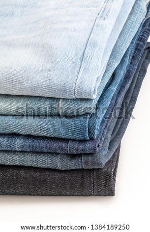 Heap of jeans of various shades. Close-up.
