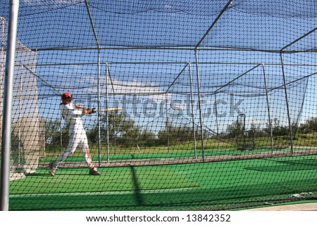 practicing hitting baseball in a batting cage Royalty-Free Stock Photo #13842352