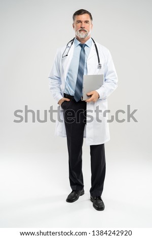 full body picture of a mature doctor holding a notepad, on white background