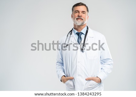 Cheerful mature doctor posing and smiling at camera, healthcare and medicine Royalty-Free Stock Photo #1384243295