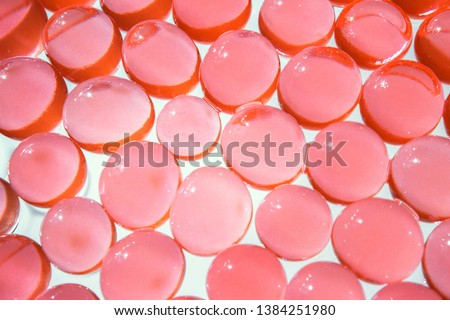 Red hydrogel balls. Bright salmon color round gel. Transparent water texture. Fresh colorful background. Macro