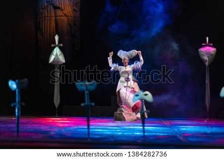 Actress in white costume plays a performance on the theater stage
