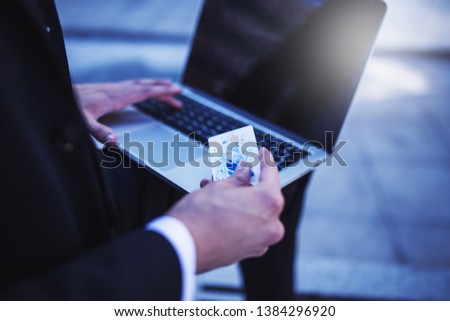 Unrecognizable businessman using credit card for online shopping
