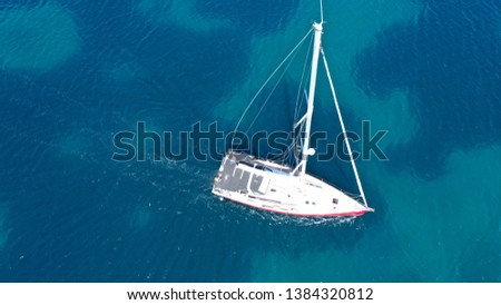 Aerial drone bird's eye view photo of small sail boat cruising in mediterranean open deep blue sea