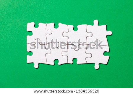 Eight pieces white jigsaw puzzle connected on green background for business presentation