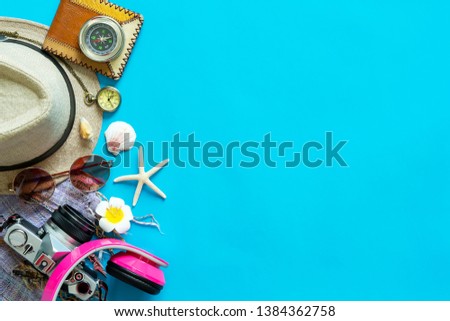 Travel and summer background concept. Camera, sunglasses, compass, hat and headphone on blue background with free space.