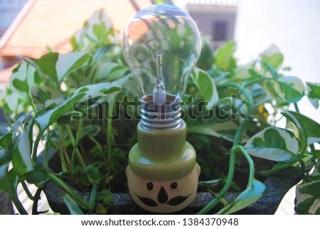 Closeup of the light bulb on a green leaf background. Using as background ecological concept. Concept of loving earth, concept of earth day, for a greener earth. The concept of saving electricity