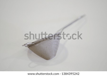 Selective focus on tea strainer isolated white background
