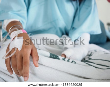 Focus on the hand of a patient in hospital ward with blurred background,  Abstract blurred of Patient in ICU ward, Hand of a patient with medical drip or IV drip in hospital ward, Healthcare concept.