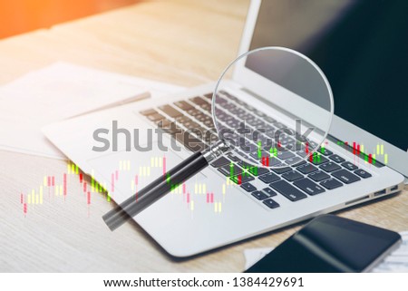 business finance magnifying glass on office table data paper background