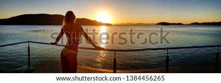 Woman watching the sunset at Hamilton Island in a bikini. Hamiton Island. 