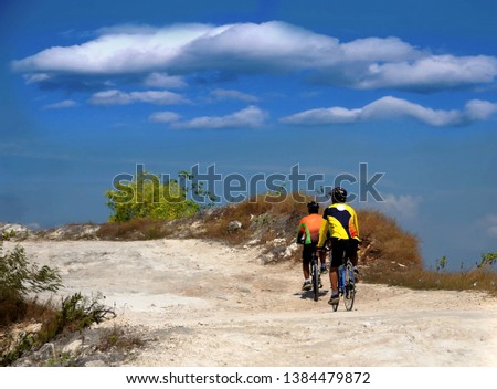 Two men cycling in jadih hills in madura, indonesia