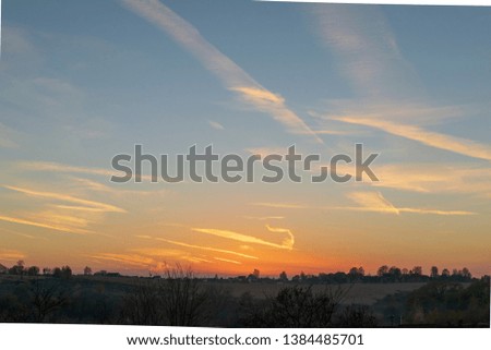beautiful sunset above the village. scenic countryside landscape. clouds and sun in the sky