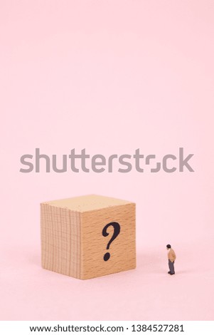 miniature man with question mark on wood cube 