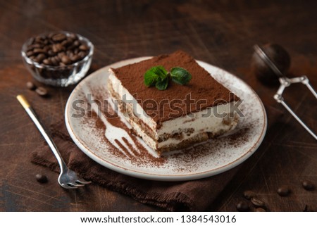 Tiramisu. Traditional italian dessert on white plate, wooden background. Selective focus Royalty-Free Stock Photo #1384543016