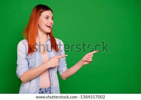 Close up photo beautiful funky she her foxy lady toothy hold hand arm finger indicate look empty space advising low little price shop wear casual jeans denim shirt isolated green bright background