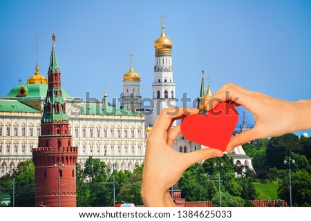 Hand hold red heart over Moscow Kremlin churches