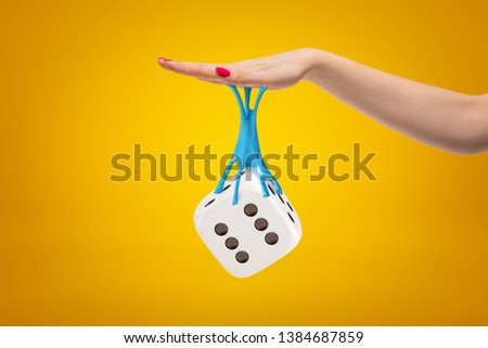 3d rendering of casino dice stuck with sticky slime to female hand on yellow background. Digital art. Objects and materials. People and objects.