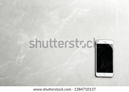 Modern smartphone with broken display and space for text on table, top view. Device repair