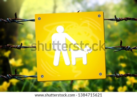 Creative Keep dogs on leash caution sign board decorated with barbed wire in front of the green nature.