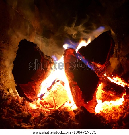 Beautiful flame brown wood dark black coal on bright yellow fire inside metal brazier. Flame burning gray coals is natural fire in barbecue. Hot flame preparation for cooking barbecue to coal fire.