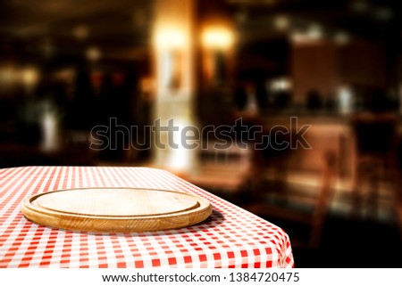Red and white tablecloth with kitchen desk and restaurant interior. Free space for your food or drink. 