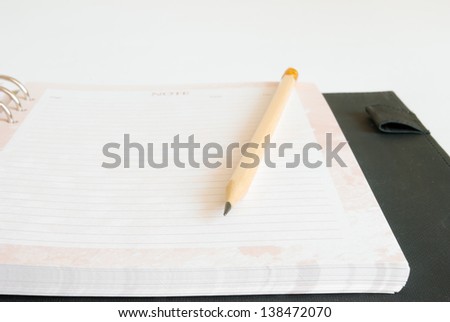 Notebook and pencil on white background.