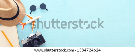 Top view banner photo of traveling concept with accessories over blue background