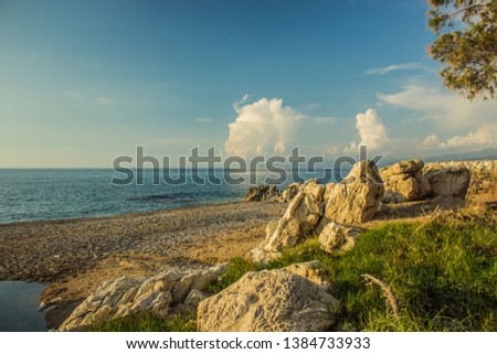 idyllic picturesque Greece beach summer scenery landscape vacation concept photography, sand stone coast line along Mediterranean sea and contrast blue sky with white clouds  