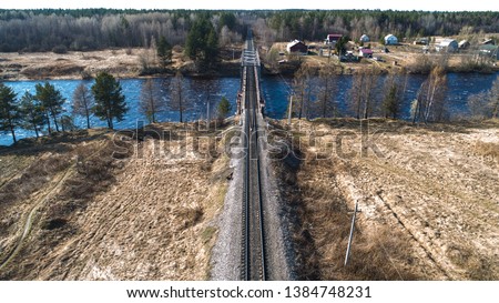 Aerial view on the rail bridge across the river in rural place in spring