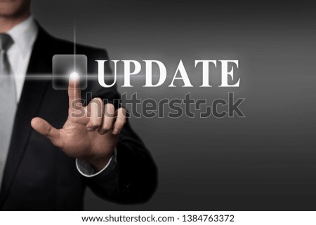 technology, internet, network, business concept - businessman in suit presses virtual touchscreen interface button - english word UPDATE