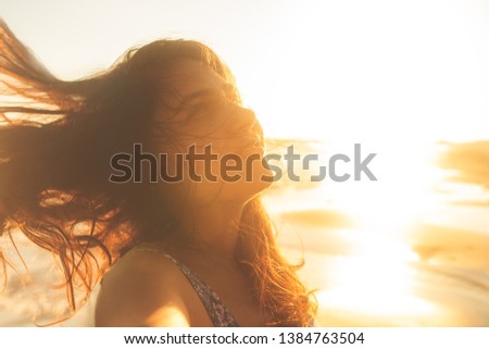 Freedom woman happy and free open arms on beach at sunny sunset.